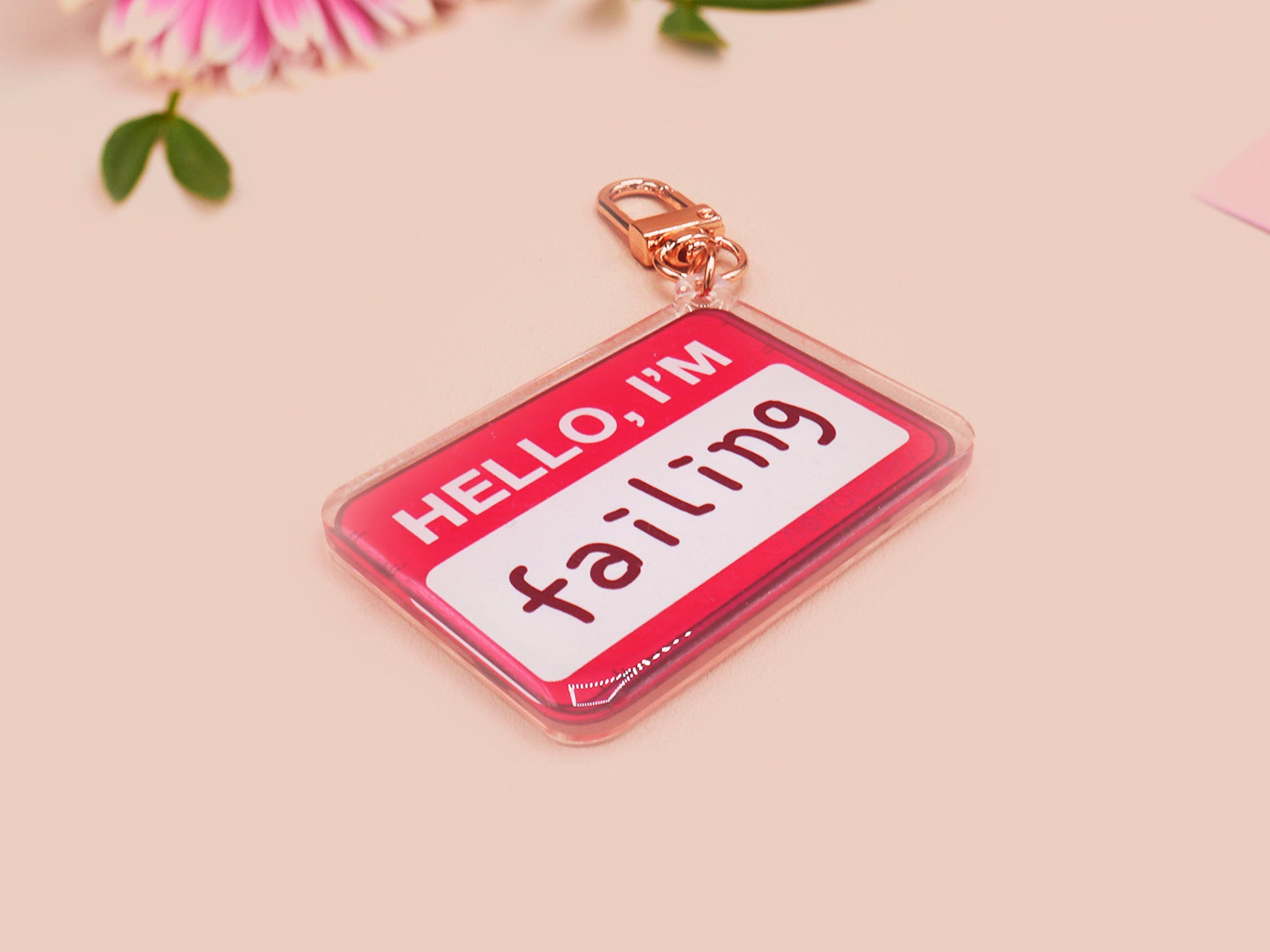 Multiple acrylic keychains with gold swivel clasps in the hello I'm name badge style with the word failing written instead of a name