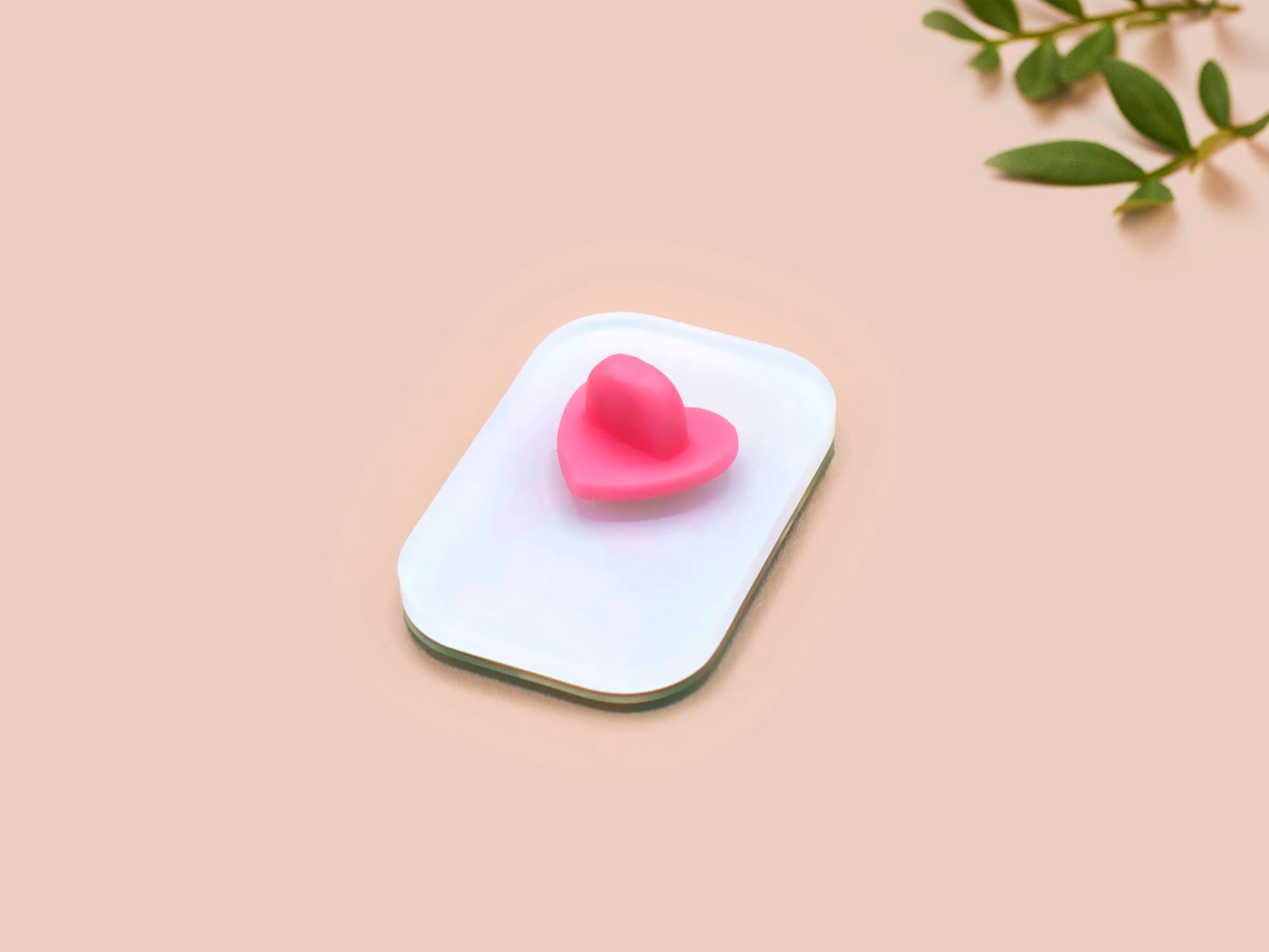 A clear acrylic pin badge with a pink heart-shaped pin back clasp. The design of the pin badge is of a cute chibi retro astronaut floating in sapce with the quote Houston I have so many problems