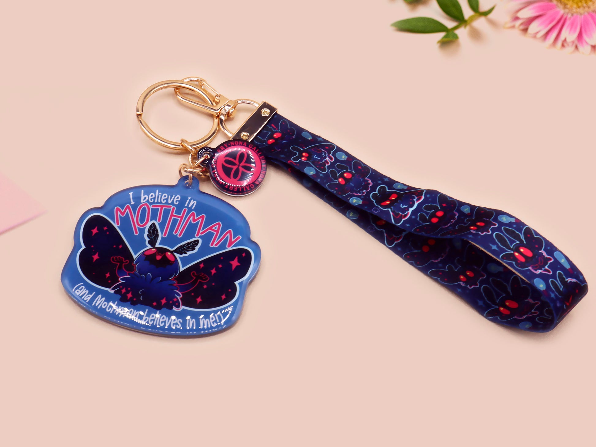 Acrylic epoxy Mothman Cryptid keychain with a large acrylic charm of a cute Mothman with the quote I believe in Mothman and Mothman belives in me, a smaller charm of a cute chibi Mothman and a matching Mothman lanyard.