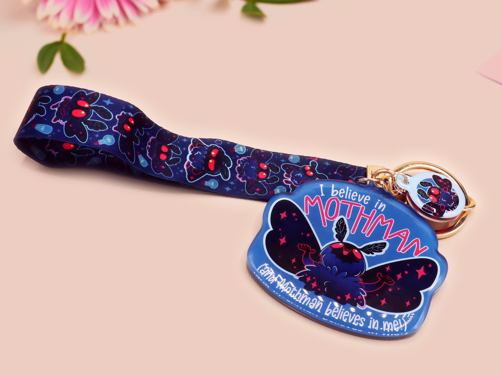 Acrylic epoxy Mothman Cryptid keychain with a large acrylic charm of a cute Mothman with the quote I believe in Mothman and Mothman belives in me, a smaller charm of a cute chibi Mothman and a matching Mothman lanyard.
