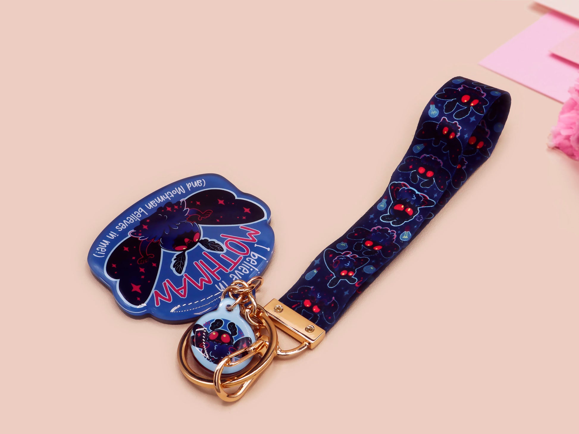 Acrylic epoxy Mothman Cryptid keychain with a large acrylic charm of a cute Mothman with the quote I believe in Mothman and Mothman belives in me, a smaller charm of a cute chibi Mothman and a matching Mothman lanyard.