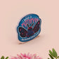 Clear acrylic pin badge with pink heart-shaped rubber pin back clasp. The design of the pin badge is a cute cartoon chibi Mothman cryptid with the quote I believe in Mothman and Mothman believes in me.