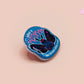 Clear acrylic pin badge with pink heart-shaped rubber pin back clasp. The design of the pin badge is a cute cartoon chibi Mothman cryptid with the quote I believe in Mothman and Mothman believes in me.