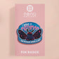 Clear acrylic pin badge with pink heart-shaped rubber pin back clasp. The design of the pin badge is a cute cartoon chibi Mothman cryptid with the quote I believe in Mothman and Mothman believes in me.