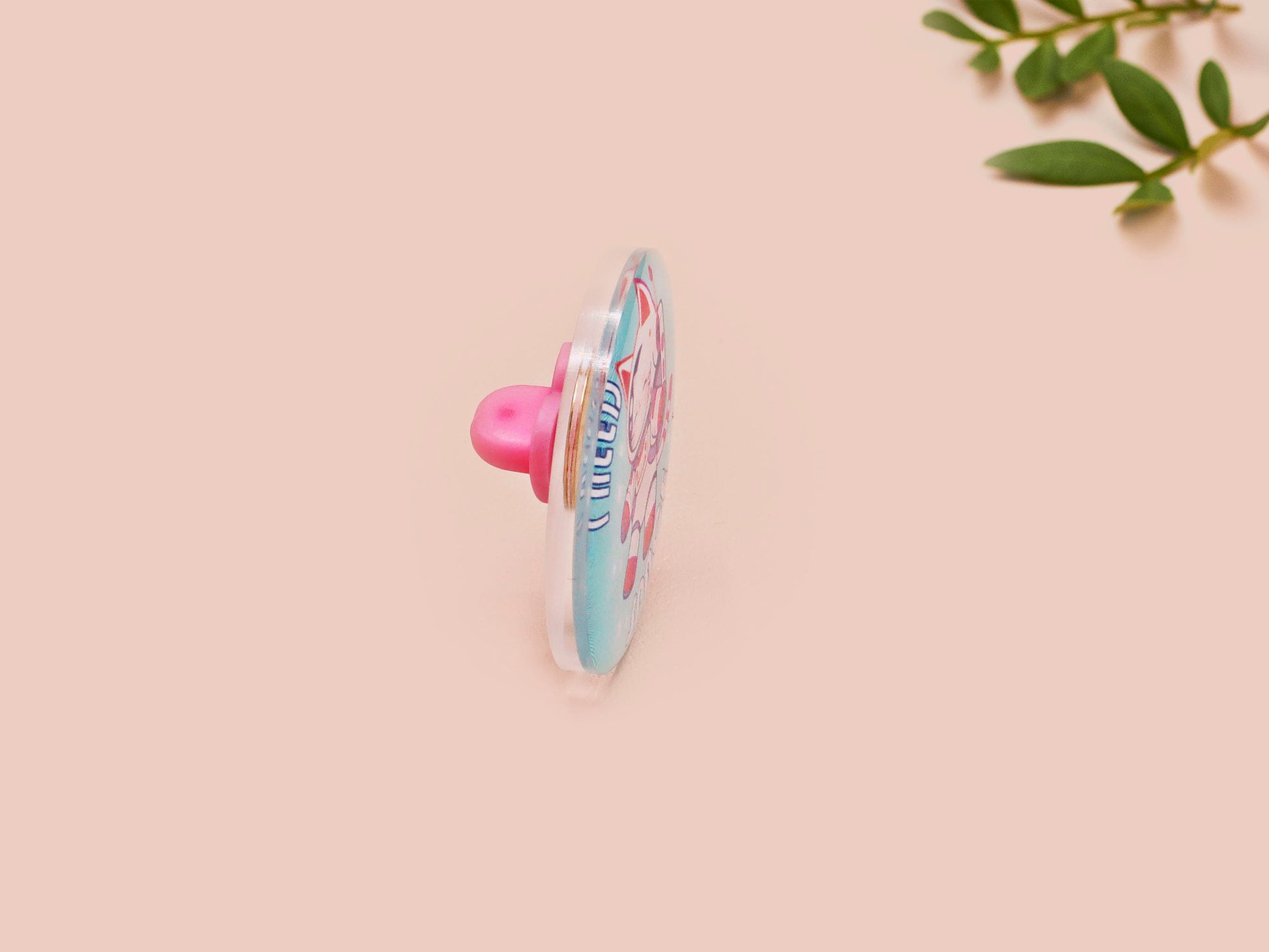 Clear acrylic pin badge with a pink heart-shaped rubber pin back clasp. The design of the pin badge is a cute chibi white cat in a retro astronaut suit with the quote I need space.