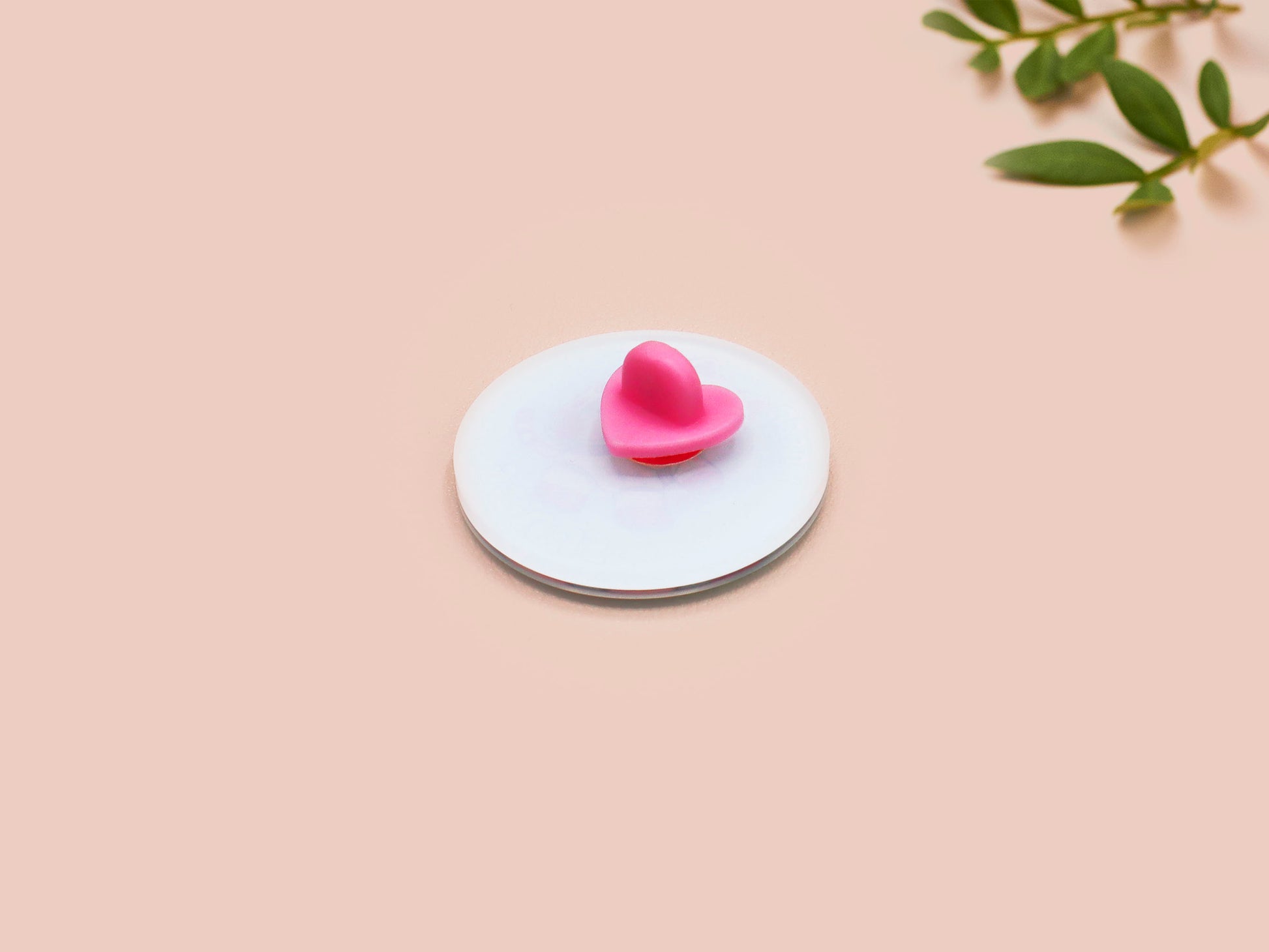 Clear acrylic pin badge with a pink heart-shaped rubber pin back clasp. The design of the pin badge is a cute chibi white cat in a retro astronaut suit with the quote I need space.