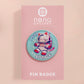 Clear acrylic pin badge with a pink heart-shaped rubber pin back clasp. The design of the pin badge is a cute chibi white cat in a retro astronaut suit with the quote I need space.