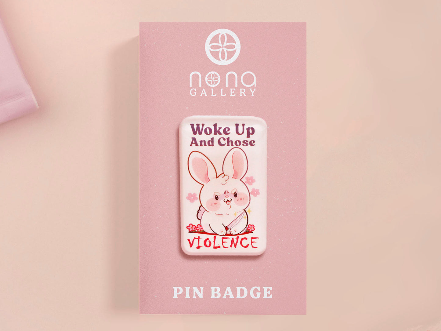 Clear acrylic pin badge with pink heart-shaped rubber pin back clasp. The design of the pin badge is a cute cartoon chibi white rabbit with the quote Woke Up And Chose Violence.