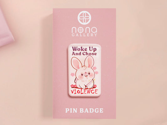 Clear acrylic pin badge with pink heart-shaped rubber pin back clasp. The design of the pin badge is a cute cartoon chibi white rabbit with the quote Woke Up And Chose Violence.