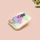 A clear acrylic pin badge with a pink heart-shaped pin back clasp. The design of the pin badge is of a cute chibi pigeon wearing a top hat crying next to a pethetic attempt at nest building with the quote I'm trying my best.