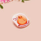 A clear acrylic pin badge with a pink heart-shaped pin back clasp. The design of the pin badge is of a cute chibi potato with the quote I'm a lil' stressed potato
