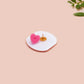 A clear acrylic pin badge with a pink heart-shaped pin back clasp. The design of the pin badge is of a cute chibi potato with the quote I'm a lil' stressed potato