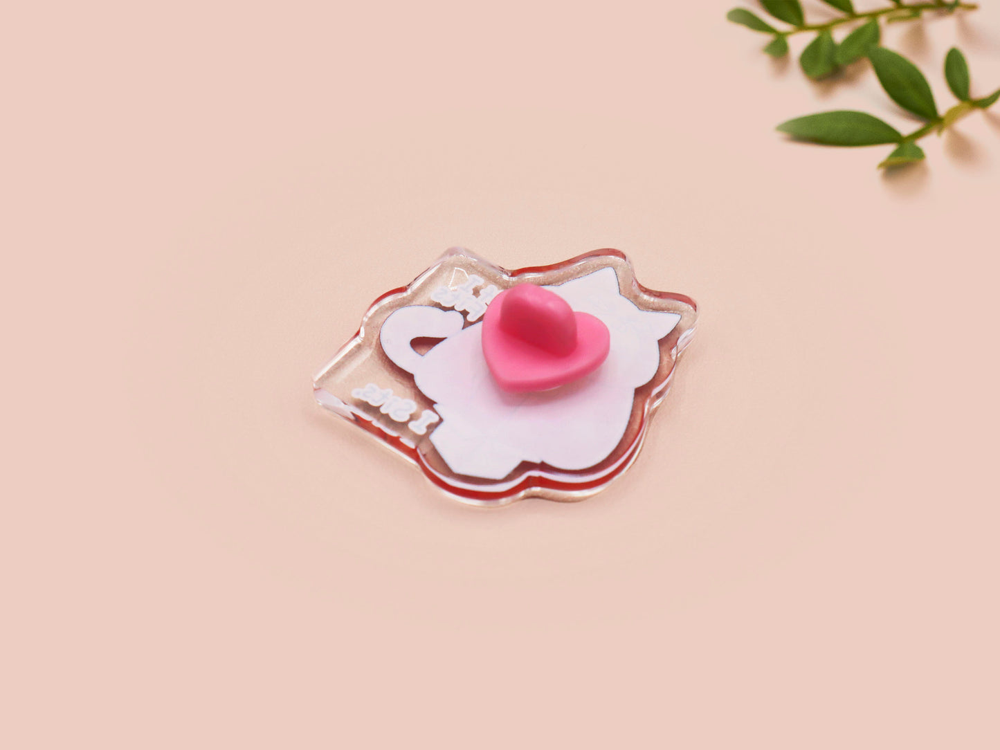 Clear acrylic pin badge with pin heart-shaped pin back clasp. The design of the pin badge is a cute cartoon ginger cat sat in a small cardboard box with the quote if I fits I sits.