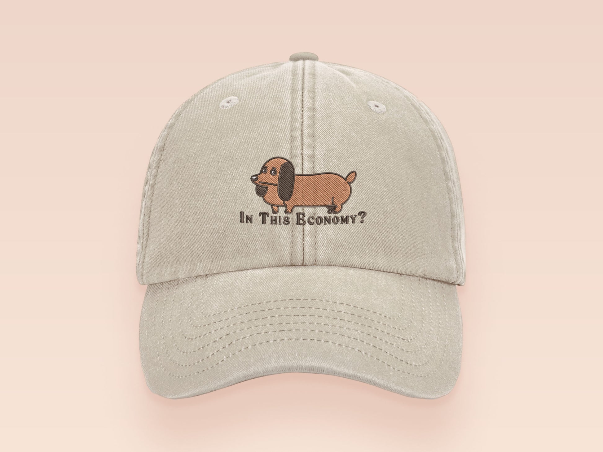 Vintage cream baseball cap with an embroidered design of a cute dachshund dog looking concerned and the quote "In This Economy?"