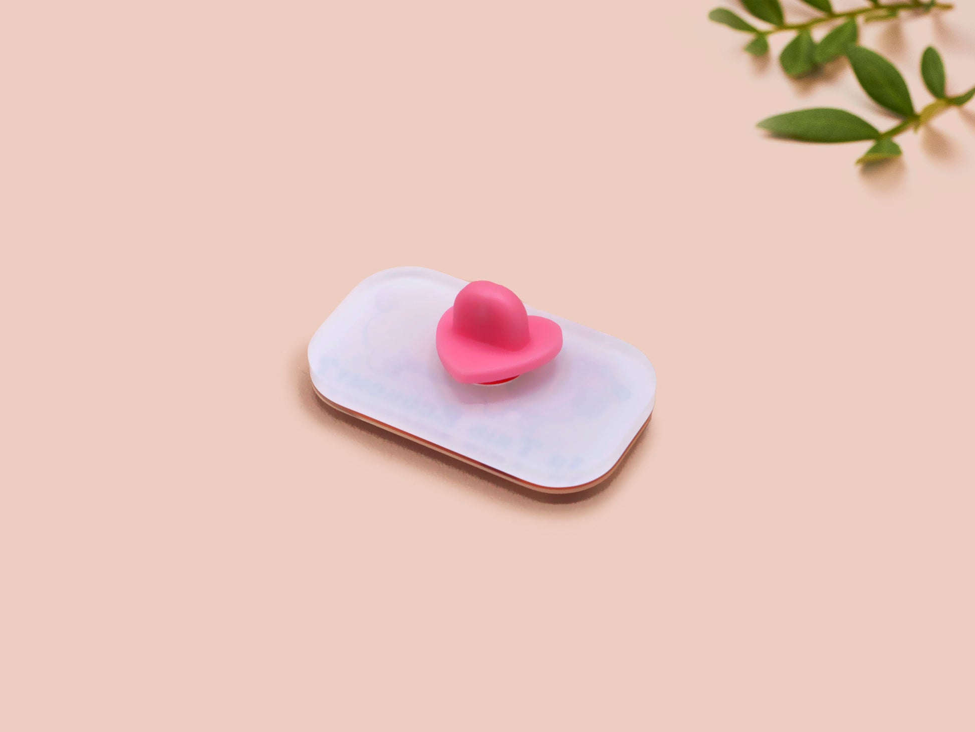 A clear acrylic pin badge with a pink heart-shaped pin back clasp. The design of the pin badge is of a cute chibi dachshund sausage dog with the quote in this economy?