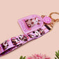 Acrylic epoxy possum keychain with a large acrylic charm of a purple screaming possum with the quote is it me am I the drama, a smaller charm of a cute crying possum and a matching purple possum lanyard.