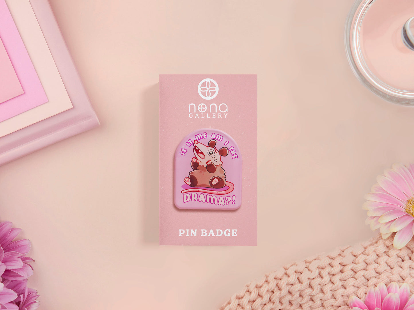 A clear acrylic pin badge with a pink heart-shaped pin back clasp. The design of the pin badge is of a cute screaming possum with the quote is it me am I the drama?