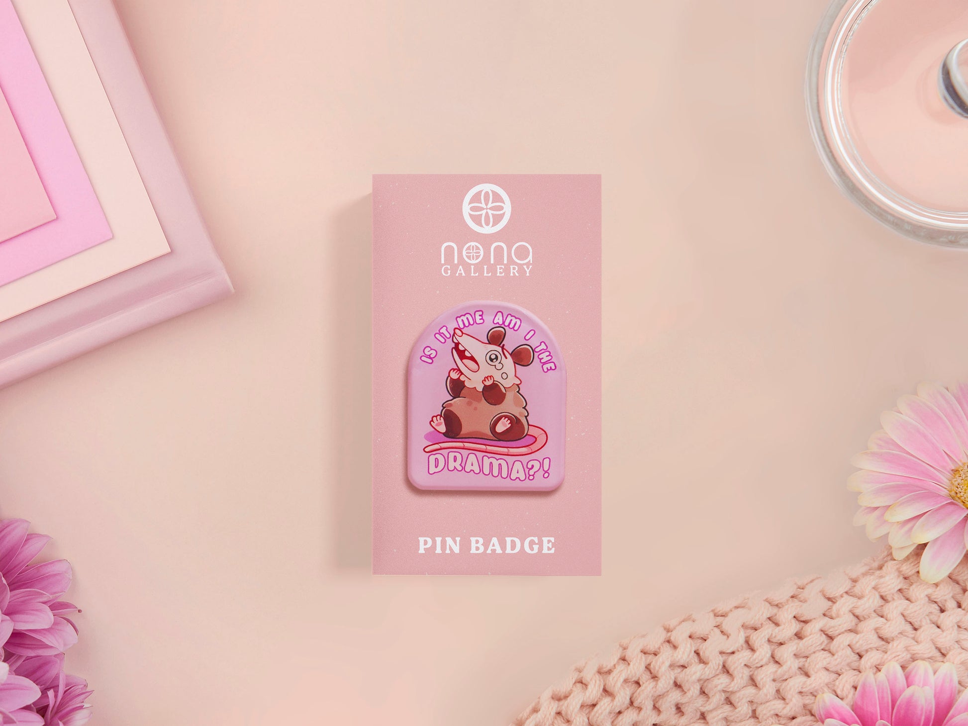 A clear acrylic pin badge with a pink heart-shaped pin back clasp. The design of the pin badge is of a cute screaming possum with the quote is it me am I the drama?