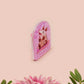 A clear acrylic pin badge with a pink heart-shaped pin back clasp. The design of the pin badge is of a cute screaming possum with the quote is it me am I the drama?