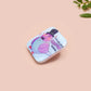 A clear acrylic pin badge with a pink heart-shaped pin back clasp. The design of the pin badge is of a cute chibi pigeon wearing a top hat with the quoteit's called fashion susan