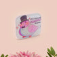 A clear acrylic pin badge with a pink heart-shaped pin back clasp. The design of the pin badge is of a cute chibi pigeon wearing a top hat with the quoteit's called fashion susan