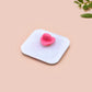 A clear acrylic pin badge with a pink heart-shaped pin back clasp. The design of the pin badge is of a cute chibi pigeon wearing a top hat with the quoteit's called fashion susan