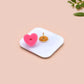 A clear acrylic pin badge with a pink heart-shaped pin back clasp. The design of the pin badge is of a cute chibi pigeon wearing a top hat with the quoteit's called fashion susan