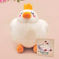 An adorable white duck bird plushie toy with cute embroidered eyes and facial expression, wearing a yellow crown hat, with a hang tag describing the duck as King Larry.