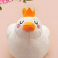 An adorable white duck bird plushie toy with cute embroidered eyes and facial expression, wearing a yellow crown hat, with a hang tag describing the duck as King Larry.