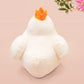 An adorable white duck bird plushie toy with cute embroidered eyes and facial expression, wearing a yellow crown hat, with a hang tag describing the duck as King Larry.