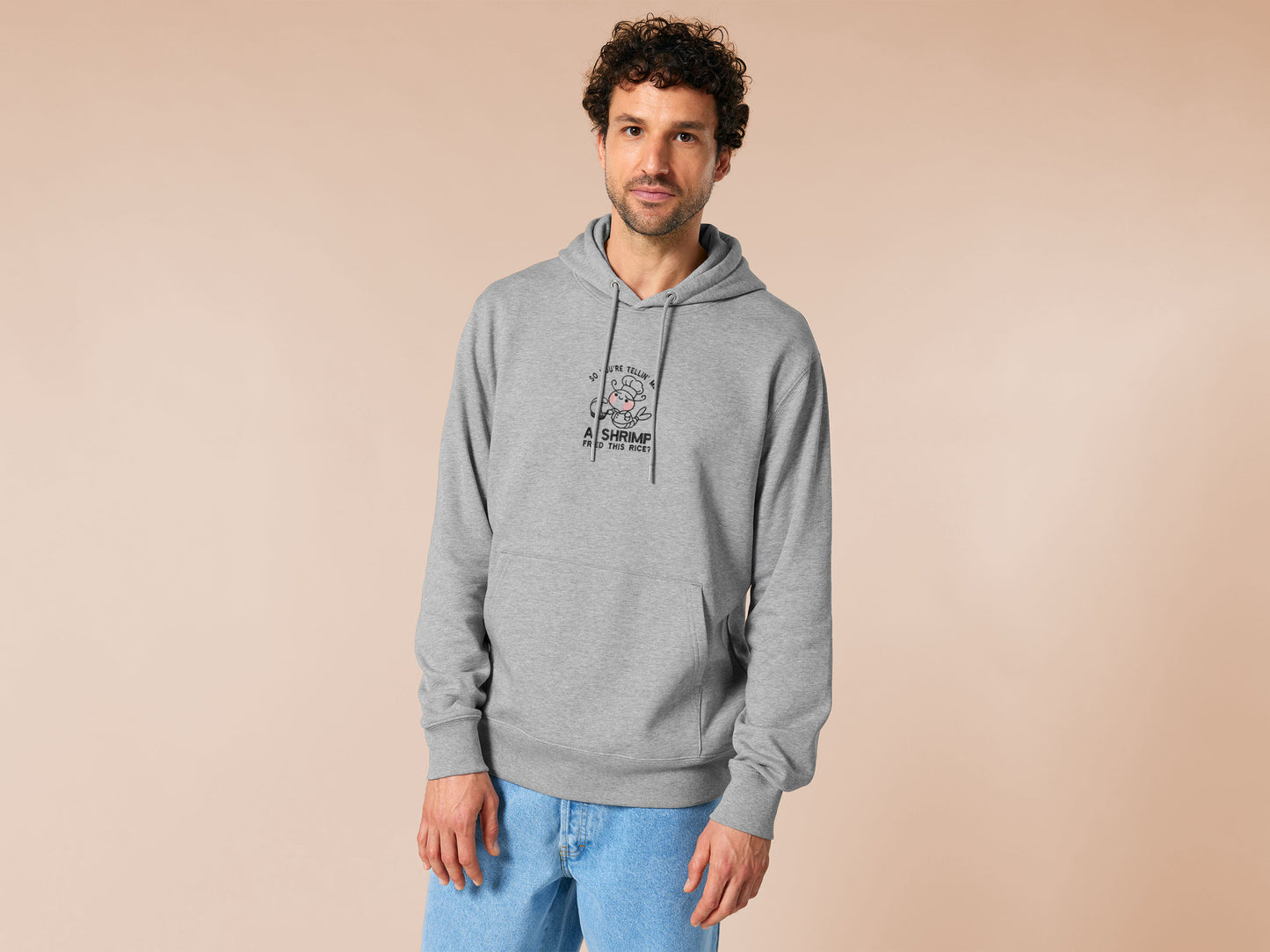 A grey embroidered hoodie design of a cute chibi shrimp with pink cheeks dressed as a chef using a frying pan surrounded by the quote So You're Telling Me A Shrimp Fried This Rice?