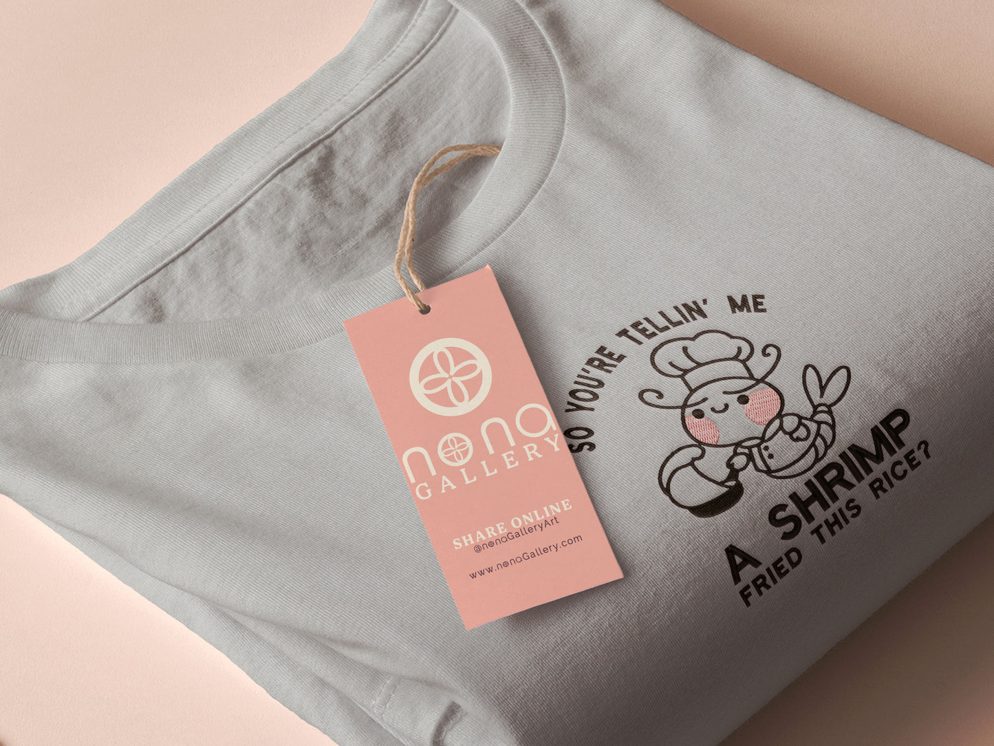 A grey embroidered t-shirt design of a cute chibi shrimp with pink cheeks dressed as a chef using a frying pan surrounded by the quote So You're Telling Me A Shrimp Fried This Rice?