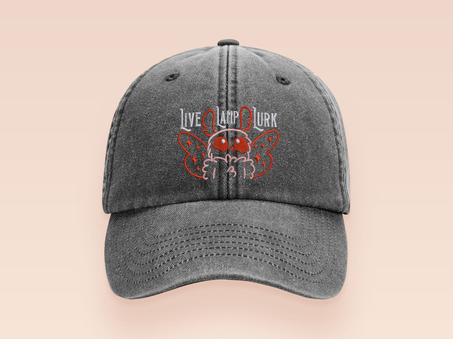 A vintage dark grey baseball cap hat with an embroidered cute chibi Mothman crytid with the quote Live Lamp Lurk.