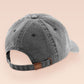 A vintage dark grey baseball cap hat with an embroidered cute chibi Mothman crytid with the quote Live Lamp Lurk.
