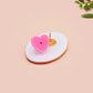 Clear acrylic pin badge with pink heart-shaped rubber pin back clasp. The design of the pin badge is a cute viral internet meme cat with a cheeky relatable reaction.