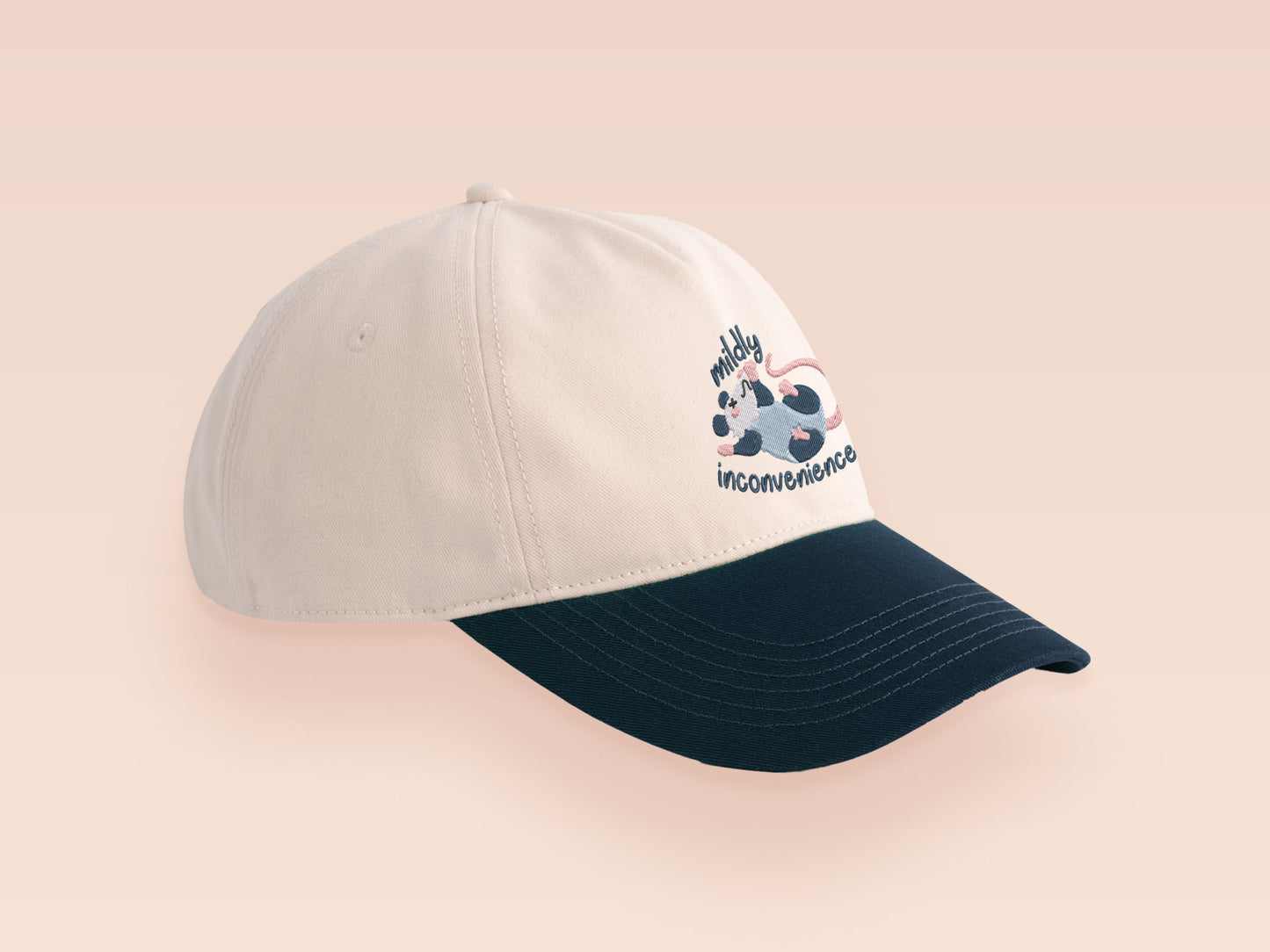 Vintage style truckers baseball cap with a contrast cream and navy peak design with an embroidered possum playing dead and the quote mildly inconveninced 