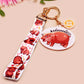 Acrylic keychain with a large charm of the fat angry pygmy hippo being picked up, a smaller charm of a cute baby hippo with the name Moo Deng in Thai and a matching mini lanyard of the pygmy hippo in multiple cute poses and expressions.