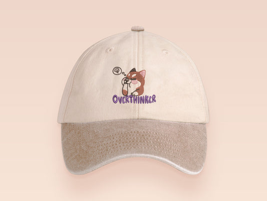 Vintage style truckers baseball cap with a contrast cream and sand peak design with an embroidered cute shiba inu dog overthinking with the quote Overthinker