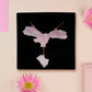 Back of Mixed material handmade necklace of chibi cartoon flying barn owl with pearlescent wings carrying a removeable spell book charm, with a gold chain and black gift box.