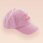 A vintage pink baseball cap hat with an embroidered cute princess cat wearing a seatbelt and holding a boba bubble tea drink with the quote Passenger Princess