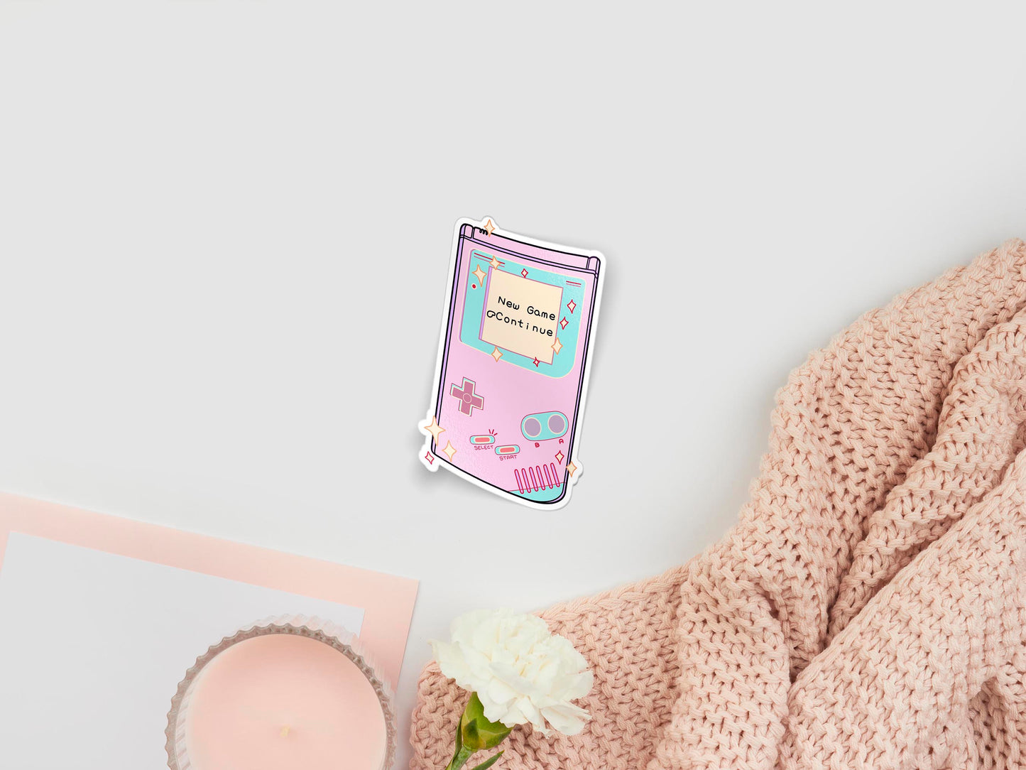 Large sticker of digital illustration cartoons of cute pastel pink nintendo gameboy   handheld console surrounded by sparkles, with the load screen new game or continue
