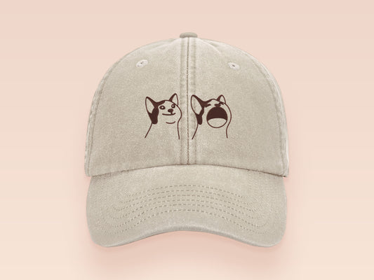 A cream baseball cap hat with an embroidered cute brown Popcat meme cat design.