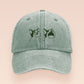 A green baseball cap hat with an embroidered cute green Popcat meme cat design.