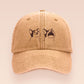 A yellow baseball cap hat with an embroidered cute brown Popcat meme cat design.