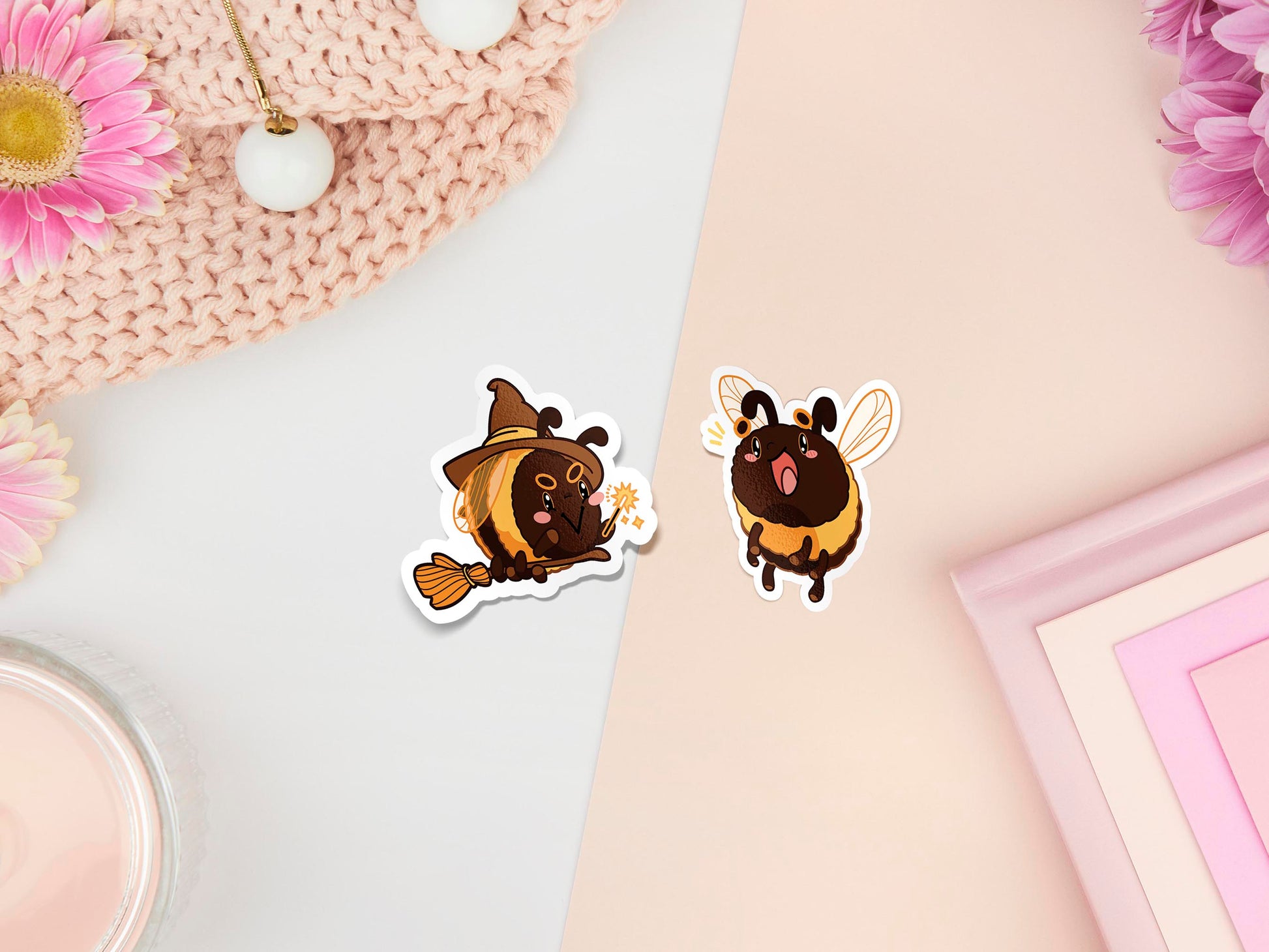 Two stickers of digital illustrated cartoon bees, one is wearing a witches hat and flying on a broomstick as they are bee-witched the other is smiling with excitement