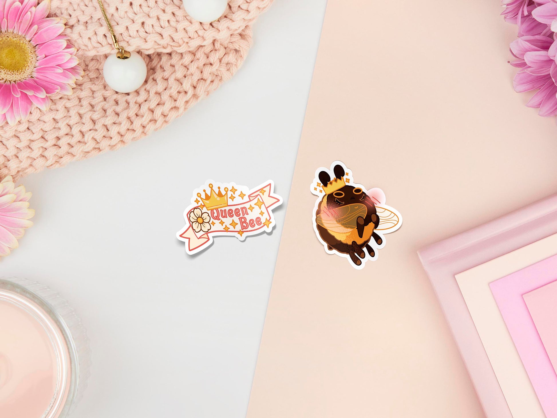Two stickers of digital illustrated cartoon ne is a banner with a crown and flower and the words Queen Bee, the other sticker is a shy blushing bee wearing a crown.