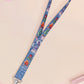Cute full legth dark blue lanyard with a double sided cryptid monster and alien pattern and silver swivel hook clasp.