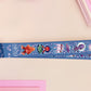 Cute full legth dark blue lanyard with a double sided cryptid monster and alien pattern and silver swivel hook clasp.