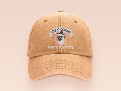 A vintage yellow baseball cap hat with an embroidered cute goose wearing a paper hat with the quote Silly Goose University
