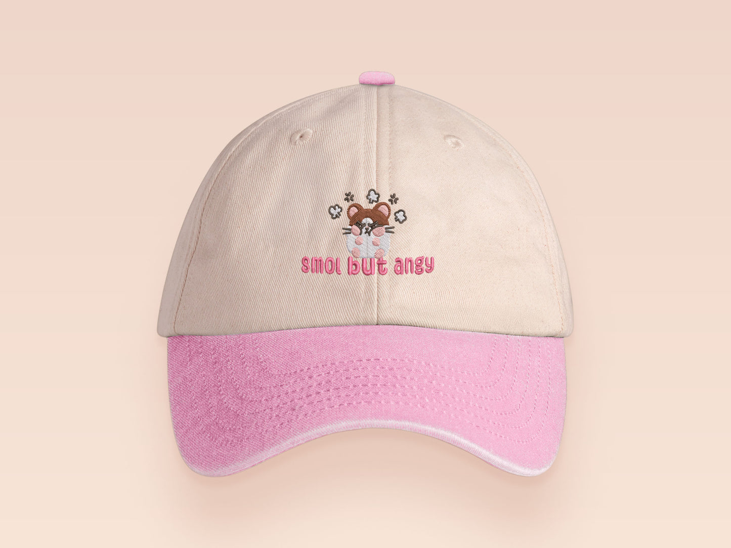 Vintage style truckers baseball cap with a contrast cream and pink peak design with an embroidered cute hanster angry and sulking with the quote smol but angy